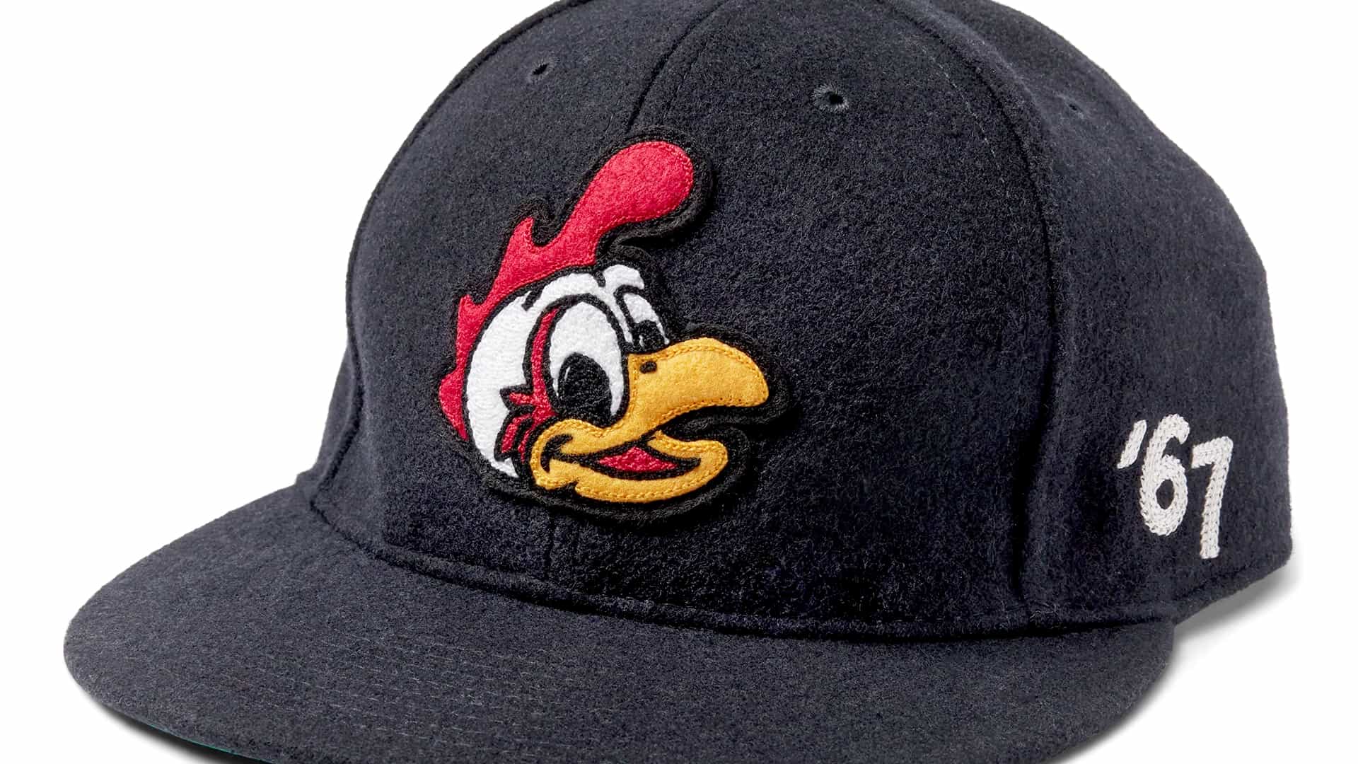 A black baseball cap with a felt texture, featuring an embroidered cartoon chicken head logo on the front. The chicken has a red comb, white feathers, and an orange beak. On the side of the cap, the number "67" is embroidered in white. The cap has a curved brim and is shown against a light background.